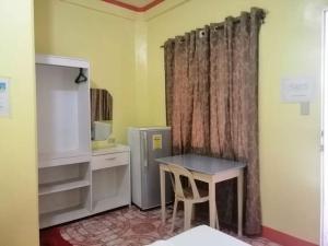 eine Küche mit einem Kühlschrank und einem Tisch im Zimmer in der Unterkunft M&E Guesthouse in Boracay