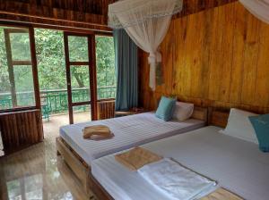 two beds in a room with windows at LePont Mu Waterfall Bungalow in Hòa Bình