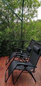 a black chair sitting on top of a porch at Cristal House Mountain View in Heredia