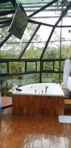 a large bathroom with a tub in a glass house at Cristal House Mountain View in Heredia