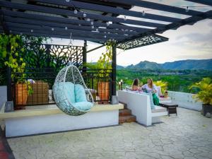 翁達的住宿－Honda Colonial Magdalena Resort，两名妇女坐在带秋千的庭院