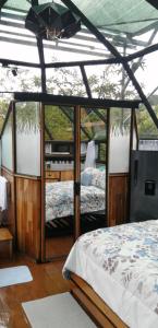 Schlafzimmer mit einem Bett und einer Glaswand in der Unterkunft Cristal House Mountain View in Heredia