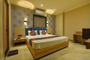 a bedroom with a bed and a desk in it at FabHotel Clive Regency Lovelock in kolkata