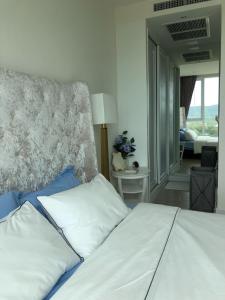 a bedroom with a bed and a view of a living room at BeachFont Bang Saray By RoomQuest Hotel in Bang Sare