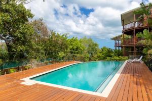 uma piscina num deque de madeira ao lado de um edifício em Casuarina Cove Apartments em Hamilton Island