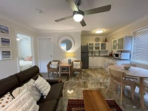 ein Wohnzimmer mit Sofa und Tisch in der Unterkunft Patonga Street Retreat in Patonga