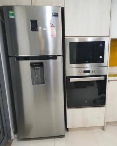 um frigorífico de aço inoxidável e um micro-ondas numa cozinha em Cozy apartment 2BR - Masteri Thao Dien , D2 em Ho Chi Minh