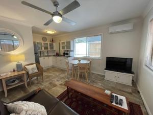 ein Wohnzimmer mit Sofa und Tisch in der Unterkunft Patonga Street Retreat in Patonga