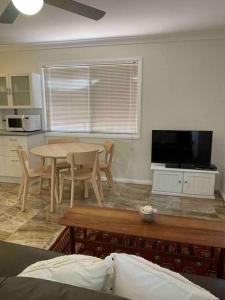 a living room with a table and a tv at Patonga Street Retreat in Patonga