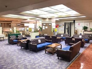 einen Wartebereich mit Sofas und Stühlen in der Lobby in der Unterkunft Ohmachiso in Akita