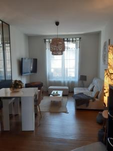 uma sala de estar com um sofá e uma mesa em Maison de ville chaleureuse em Brive-la-Gaillarde