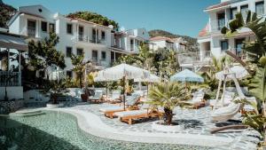 a pool at a hotel with chairs and umbrellas at Salonika Suites in Oludeniz