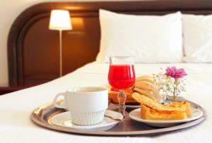 a tray with a cup of coffee and a plate of food at Hotel Aitue in Temuco