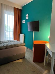 a bedroom with a bed and a green wall at HoteLPension am Thermalbad in Bad Nenndorf