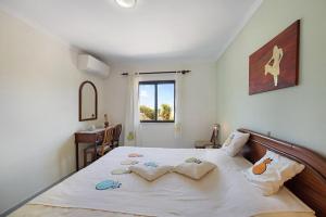 una camera da letto con un letto con lenzuola bianche e una finestra di Apartamento Mar-colina-sol a Carvoeiro
