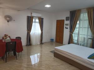 - une chambre avec un lit, une table, une table et des chaises dans l'établissement Haji Ineng Homestay- Guest House, à Kota Samarahan