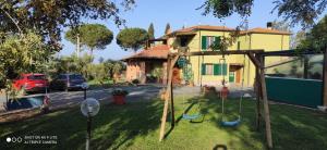 un patio con columpio frente a una casa en Agriturismo Poggio all'Olivo, en Follonica