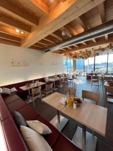 ein Restaurant mit Sofa, Tischen und Stühlen in der Unterkunft Auszeit Cafè & Hotel in Oberwörnitz