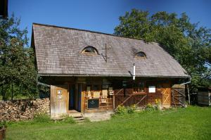 an old house with a shingled roof and a yard at Babou Maramures in Breb +15 photos