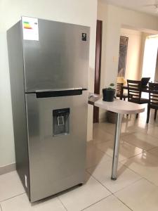 a stainless steel refrigerator in a room with a table at Exclusivo y acogedor con ascensor Directo en Urbanización la Merced in Trujillo