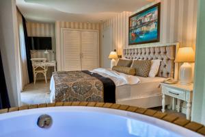 a bedroom with a bed and a bath tub at Salonika Suites in Oludeniz +193 photos
