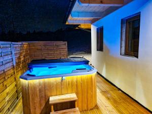 une grande baignoire en bois assise sur une terrasse en bois dans l'établissement EM Gorce Resort, à Waksmund