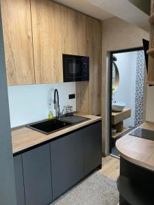 una cucina con lavandino e forno a microonde di D&N Apartments Синеморец a Sinemorets