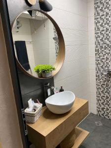 a bathroom with a bowl sink and a mirror at D&N Apartments Синеморец in Sinemorets