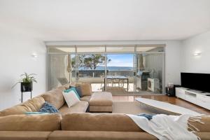 - un salon avec un canapé brun et une vue sur l'océan dans l'établissement Apartment 18 Kalimna, à Lorne