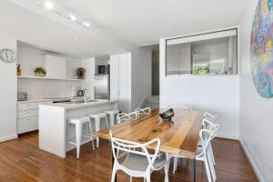 Il comprend une cuisine et une salle à manger avec une table et des chaises en bois. dans l'établissement Apartment 18 Kalimna, à Lorne