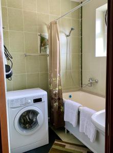 een badkamer met een wasmachine en een bad bij Apartment in the centre of Karakol in Karakol
