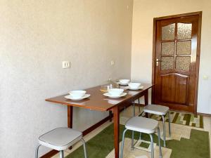 a table with bowls and stools in a room at Apartment in the centre of Karakol in Karakol
