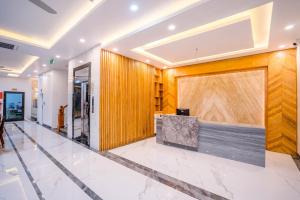 een lobby van een gebouw met een houten muur bij Khách Sạn Đại Dương FLC Sầm Sơn in Sầm Sơn