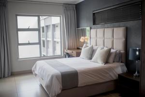 a bedroom with a large bed with a large window at Stays With DMWA in Johannesburg