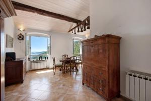 a dining room with a large wooden cabinet and a table at Cottage con vista mare in Zoagli
