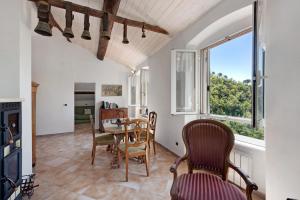 a dining room with a table and chairs and a window at Cottage con vista mare in Zoagli