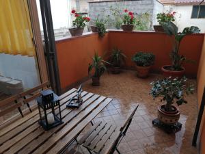 un balcone con panca in legno e piante in vaso di La Terrazza Zen a Catania