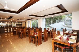 a dining room with wooden tables and chairs at Ashoka Resort Pvt. Ltd in Chitwan