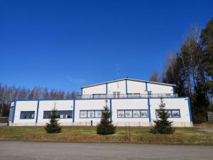 a large white building with trees in front of it at The HOME of Hiisi in Nummela