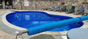 - une piscine bleue entourée de chaises dans l'établissement Heated Swimming Pool Looe Polperro Cornwall Holiday Home, à Looe