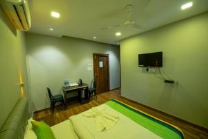 um quarto com um sofá, uma mesa e uma televisão em HOTEL MITTAL GARDEN em Siliguri