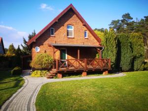 a brick house with a walkway in front of it at Leśna Chatka in Śmigiel