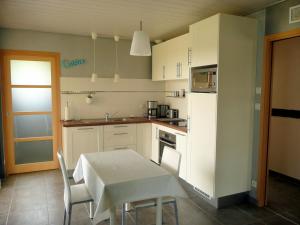 a kitchen with a table and a white table and chairs at Holiday home, Telgruc sur Mer in Telgruc-sur-Mer