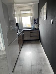 a kitchen with a window and a tile floor at Centrum 9 in Kołobrzeg +9 photos
