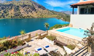 una casa con piscina junto a un lago en Du Lac Villas en Kournás