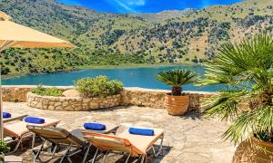Du Lac Villas في Kournás: فناء به طاولات وكراسي وبحيرة