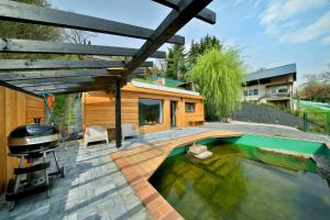 a backyard with a grill and a swimming pool at Apartmán Malá Skála in Malá Skála