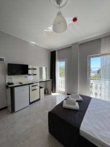 a bedroom with a large bed and a kitchen at Otel Beyaz İnci in Palamutbuku