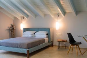 una camera da letto con un letto, un tavolo e una sedia di Luxury Villa Matzourana by PosarelliVillas a Gardeládes Altre 28 foto