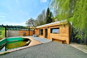 a house with a swimming pool next to a building at Apartmán Malá Skála in Malá Skála